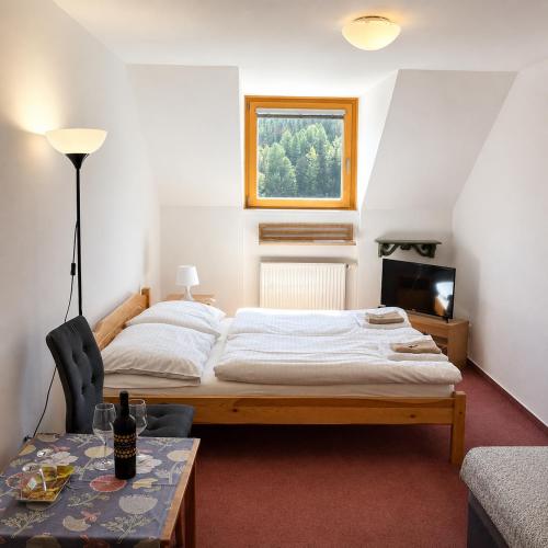 a bedroom with a large bed and a table at Hotel Modřin wellness v ceně in Pec pod Sněžkou
