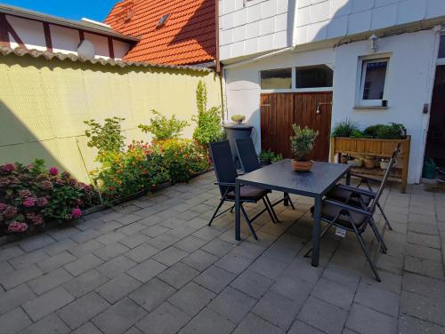 a patio with a table and chairs and a fence at Ferienwohnung Amelie in Ribnitz-Damgarten