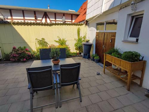 a patio with a table and chairs in a yard at Ferienwohnung Amelie in Ribnitz-Damgarten