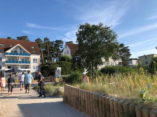 a group of people walking down a sidewalk at Blaumuschel Haus A Wohnung 2 - DH in Lubmin