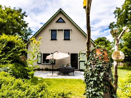 a white house with a table and an umbrella at Ferienwohnung im Spöckerhus in Tribohm