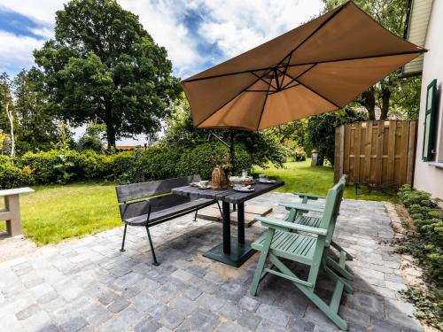 a patio with a table and two chairs and an umbrella at Ferienwohnung im Spöckerhus in Tribohm