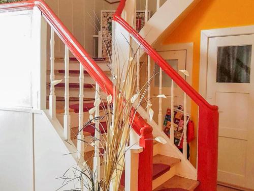 a red spiral staircase with a plant in a room at City Urlaub in Ribnitz-Damgarten