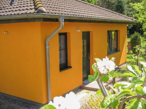 a small yellow house with a hose at Ferienhaus Bohne in Rubitz