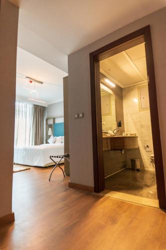 an open door to a room with a bed and a bathroom at Nile Suites Plaza Hotel Apartments in Cairo
