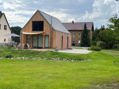a large wooden house in a field of grass at Gribertshaus in Klein Uhyst