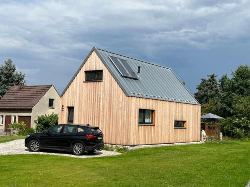 a black car parked in front of a wooden barn at Gribertshaus in Klein Uhyst