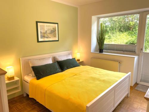 a bedroom with a large yellow bed with a window at Klingl Ankerplatz Perle in Schönhagen