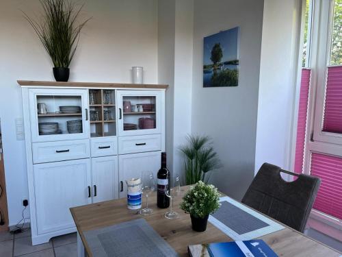a dining room with a table and a white hutch at Klingl Ankerplatz Perle in Schönhagen