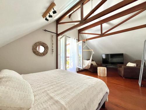 a bedroom with a white bed and a tv at Case Christal in Saint-Louis