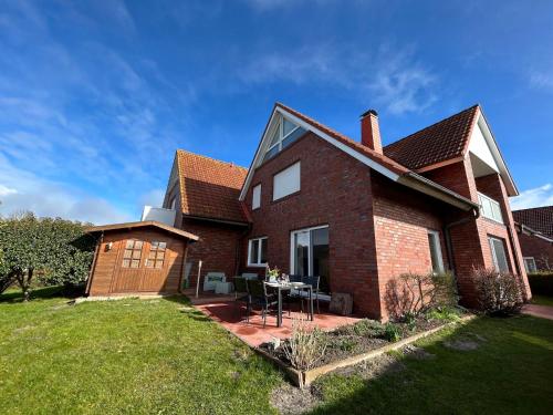 a brick house with a table in the yard at Deichwärts in Carolinensiel