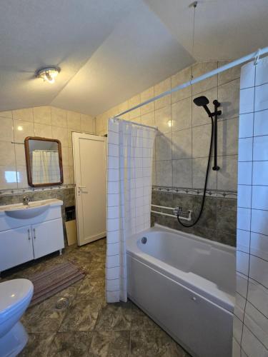 a bathroom with a tub and a toilet and a sink at Good Hostel Prishtina in Prishtinë
