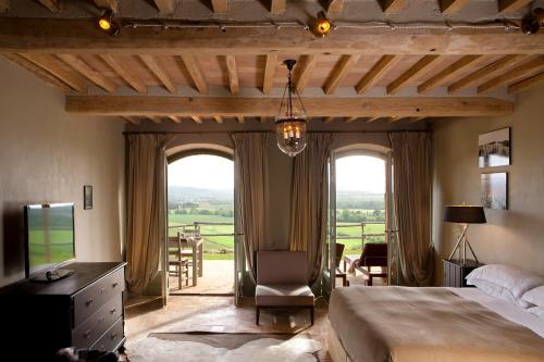 sypialnia z łóżkiem i dużym oknem w obiekcie Wine Resort Conti di San Bonifacio w mieście Montemassi