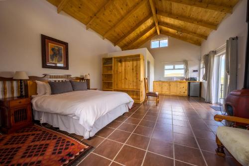 a bedroom with a large bed in a room with wooden ceilings at De Ark Mountain Lodge in Clarens
