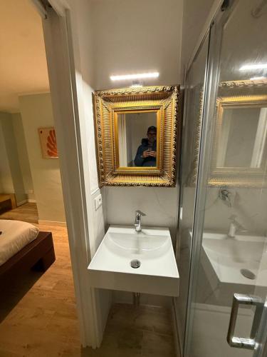 a man taking a picture of a bathroom with a sink at Superiore 33 room apartment in Pignone