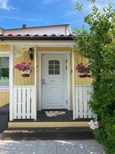a yellow house with a white door and flowers at "Villa" Rotkäppchen in Binz