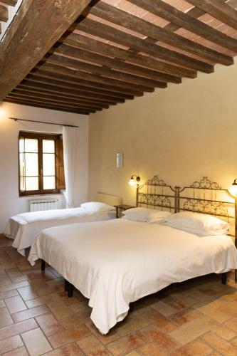 two beds in a room with a wooden ceiling at L'Arcadia in Pietrasanta