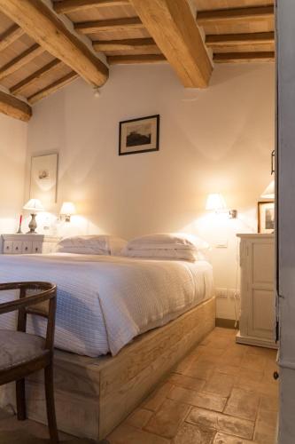 a bedroom with a bed and a table and a chair at Wine Resort Conti di San Bonifacio in Montemassi