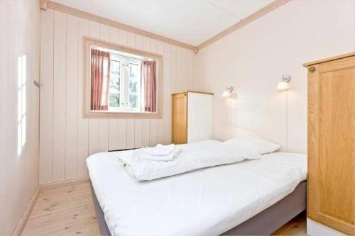 a bedroom with a large white bed with a window at Hafjell apartment, Ilsetra in Øyer