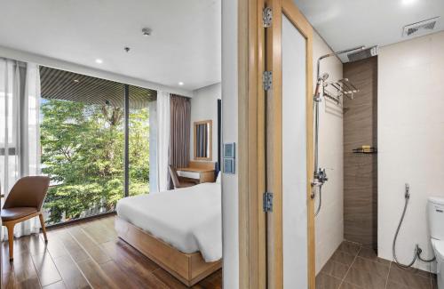 a bedroom with a bed and a bathroom with a shower at Seasol Beach Boutique hotel in Danang