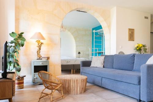a living room with a blue couch and a bed at Domaine Ecoline in Sadirac