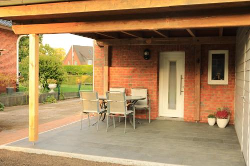 a patio with a table and chairs on a brick building at Ferienwohnung im Auenland in Bad Bramstedt
