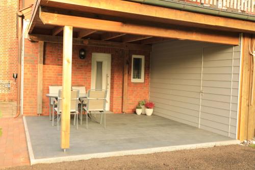 a patio with a table and chairs on it at Ferienwohnung im Auenland in Bad Bramstedt