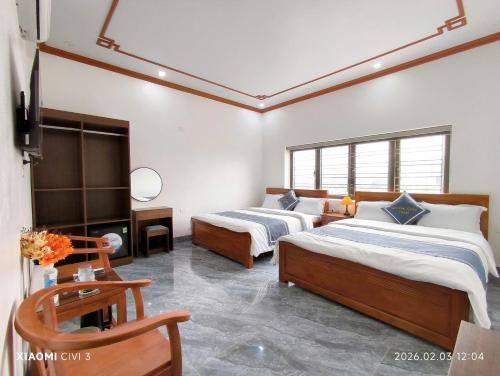 a bedroom with two beds and a tv in it at Tam Coc Cozy Hotel in Vũ Lâm