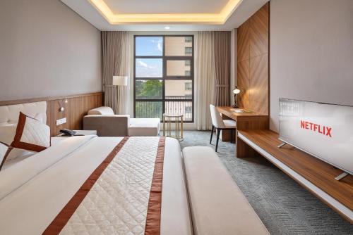 a hotel room with a king sized bed and a tv at Tao Dan Hotel in Ho Chi Minh City