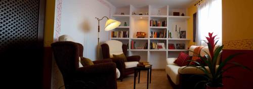 a living room with a couch and chairs and a book shelf at La Posada De Santa Ana in Tramacastilla
