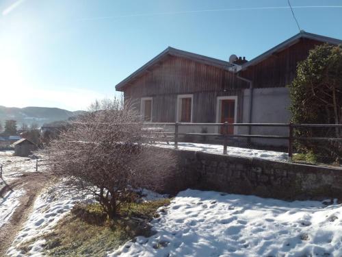 a house in the snow in front of a building at Equi'val in Le Tholy