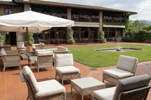 a patio with chairs and an umbrella and a fountain at Relaisfranciacorta in Corte Franca