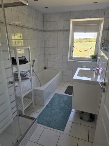 a bathroom with a tub and a sink at Ferienwohnung Ahoi in Langwedel