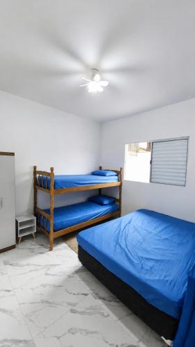 a bedroom with two bunk beds and a ceiling at Beach House 96 in Itanhaém