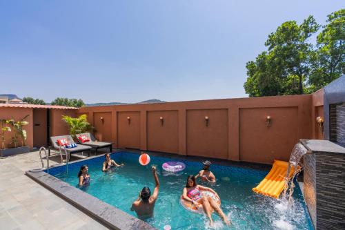 a group of people playing in a swimming pool at Moustache Hostel Lonavala in Malavli