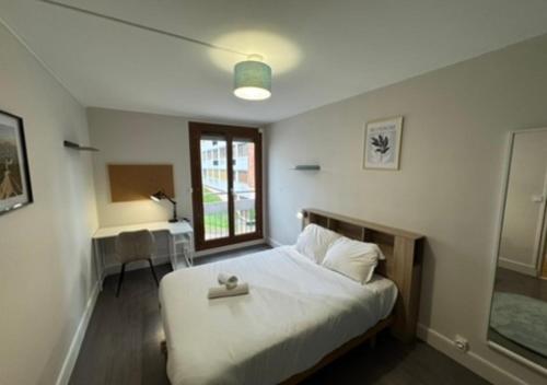 a bedroom with a bed and a window at T5 cosy lumineux in Amiens