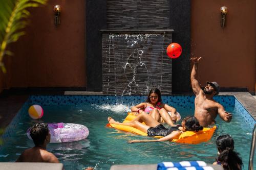 a group of people in a pool playing with a ball at Moustache Hostel Lonavala in Malavli
