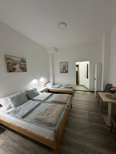 a bedroom with two beds in it with a table at Apartman Milanović in Pribojska Banja