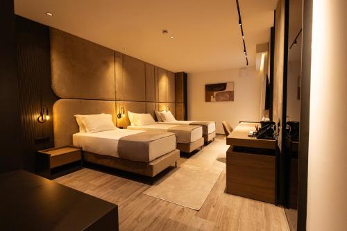a hotel room with two beds and a table at Sapphire Hotel in Prizren
