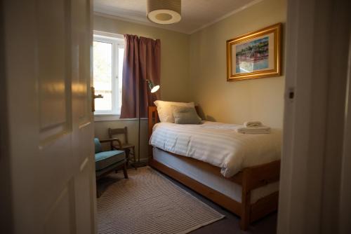a small bedroom with a bed and a window at Penlarach House in Oban