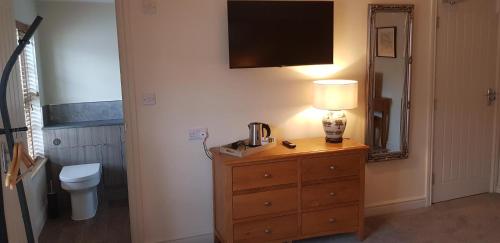a bathroom with a dresser with a lamp and a toilet at The Star Inn in North Dalton