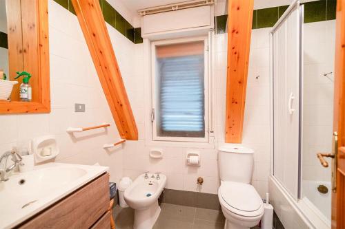 a white bathroom with a toilet and a sink at Chalet Etna dreamers in Nicolosi