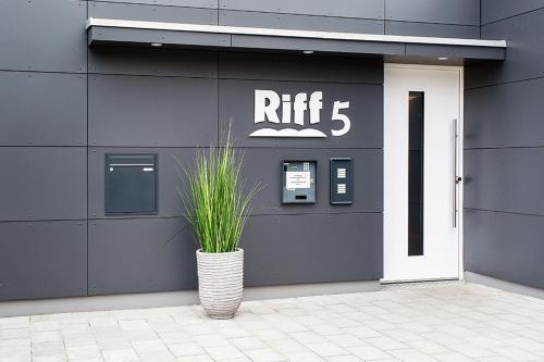 a building with a rift sign and a potted plant at Riff5 Wohnung 6 in Borkum