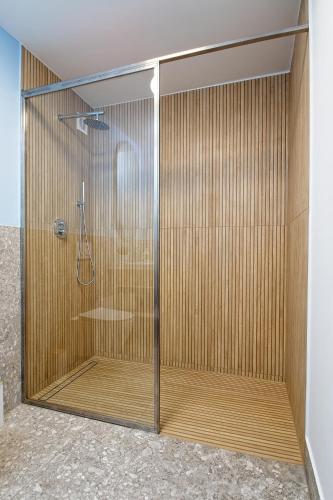 a shower with a glass door in a bathroom at Marina Apartamenty ChKŻ in Charzykowy