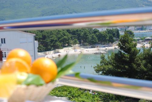 a view of a beach from a window with a basket of fruit at Rooms Split in Split