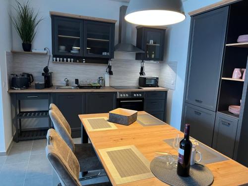 a kitchen with a wooden table with a bottle of wine at Klingl Ankerplatz Muschel in Schönhagen
