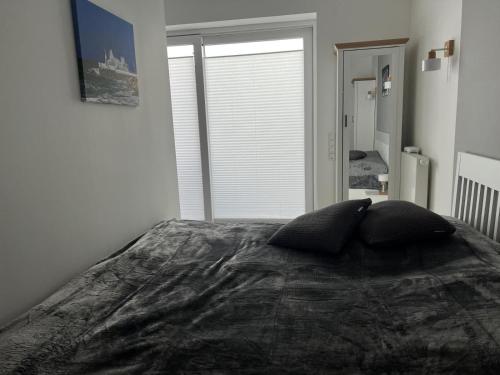 a bedroom with a large bed with two pillows on it at Klingl Ankerplatz Muschel in Schönhagen