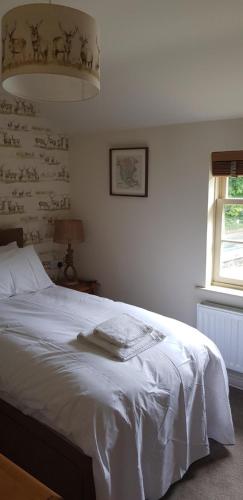 a bedroom with a white bed and a window at The Star Inn in North Dalton