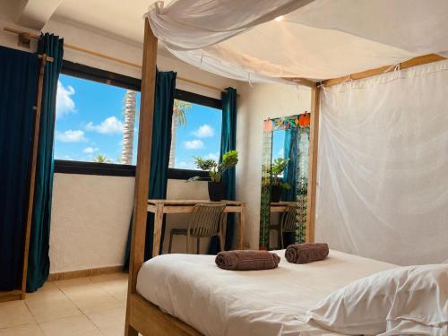 a bedroom with a canopy bed and a window at La Cabane du Pêcheur Atlantic Evasion in Dakar