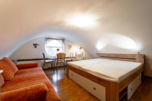 a bedroom with a bed and a couch and a table at Chata Horec in Štrba
